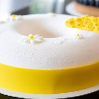 Wiosenny tort musowy biało żółty z dekoracją z czekolady w kształcie plastra miodu